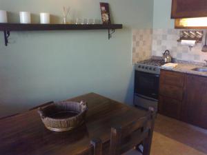 a kitchen with a wooden table and a stove at Departamento Piedra del Condor in San Carlos de Bariloche