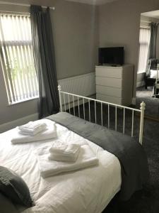 a bedroom with a bed with two towels on it at Two Little Ducks Guesthouse in Ellesmere Port
