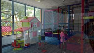 a girl in a play room with a toy house at Apartament Zielony 310 in Kołobrzeg