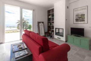 een woonkamer met een rode bank en een televisie bij Villa Palm Hill in Piedimonte Etneo