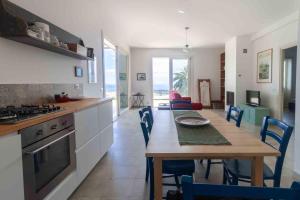 een keuken en eetkamer met een tafel en stoelen bij Villa Palm Hill in Piedimonte Etneo