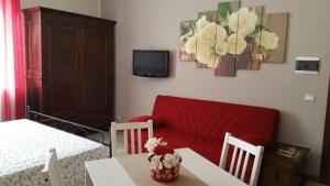 salon z czerwoną kanapą i stołem w obiekcie La Casatella Agriturismo w Albie