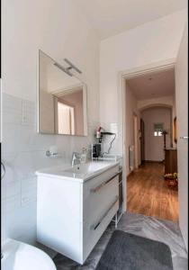 uma casa de banho branca com um lavatório e um espelho em Rina's House La Spezia em La Spezia