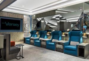 a waiting room with blue chairs and a tv at Hotel Versey Chicago Lincoln Park in Chicago