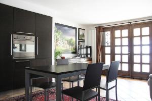 uma sala de jantar com uma mesa preta e cadeiras em Murano Garden House em Murano