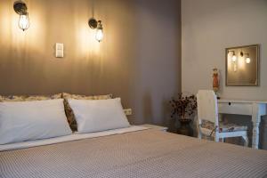 1 dormitorio con cama con almohadas blancas y escritorio en InGreen apartment, en Potamiá
