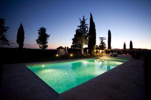 una piscina in un cortile posteriore di notte di Guadalupe Tuscany Resort a Braccagni