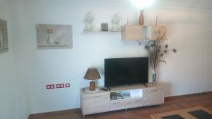 a living room with a flat screen tv on a entertainment center at Paraiso Huertano in Alquerías
