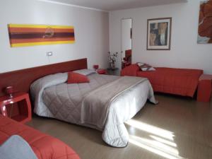 ein Schlafzimmer mit einem großen Bett und einem roten Sofa in der Unterkunft Aria di Casa in Rionero in Vulture