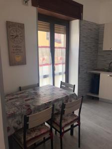 a dining room table with chairs and a clock on the wall at Piccolo fiore in Capaccio-Paestum