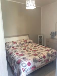 a bedroom with a bed with a floral comforter at Piccolo fiore in Capaccio-Paestum