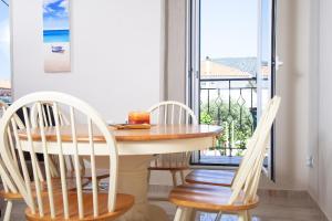 a dining room with a table and chairs and a balcony at Villa @ Poros in Poros