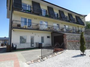 a building with balconies on the side of it at MAX Apartamenty - Pokoje - Domki - Restauracja - Basen in Mielno