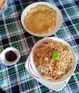 una mesa con dos platos de comida y un tazón de avena en Casa Vista Hermosa Quito, en Quito