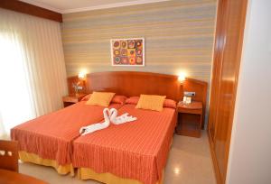 um quarto com uma cama com uma pessoa deitada sobre ela em Hotel Portonovo no Portonovo