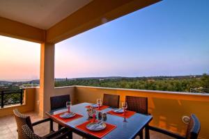 a dining room with a table and chairs on a balcony at Villa Emilie in Agios Dimitrios