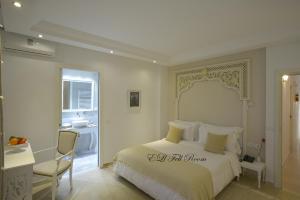 a white bedroom with a bed and a bathroom at Dar Corniche La Marsa (Adults Only) in La Marsa