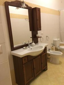 ジャルディーニ・ナクソスにあるLa Terrazzaのバスルーム(洗面台、鏡、トイレ付)