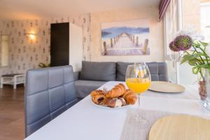 a table with a glass of orange juice and a plate of bread at Apartamento costa del oro in Torrox Costa