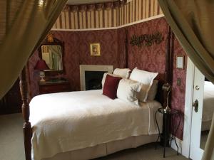 a bedroom with a white bed with red walls at Churchill Manor in Napa