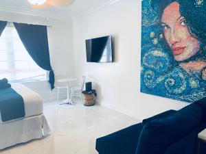 un soggiorno con un dipinto di una donna sul muro di Beach House BEACHFRONT STUDIO 107 a Miami Beach