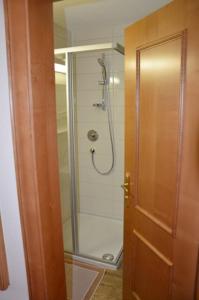 a bathroom with a shower with a glass door at Hotel-Pension Strolz in Mayrhofen