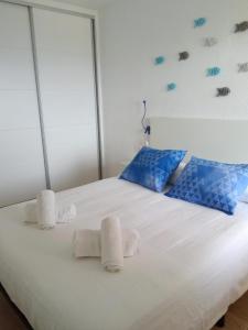 a bedroom with a white bed with towels on it at El Amanecer de Calpe 2 in Calpe