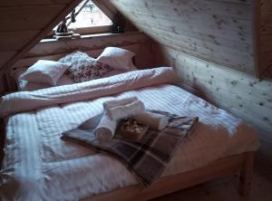 Schlafzimmer mit einem Bett und einem Tablett mit Handtüchern in der Unterkunft Arcychata Zakopane in Zakopane