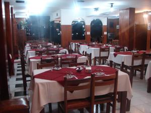 a restaurant with tables with red and white tablecloths at Cheltum Hotel in Trelew