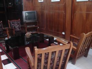 a living room with a table and chairs and a tv at Cheltum Hotel in Trelew