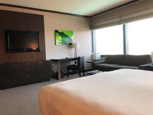 a hotel room with a bed and a couch and a television at Luxury Suites International at Vdara in Las Vegas