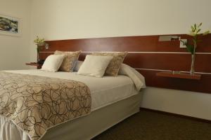 a bedroom with a large bed with a wooden headboard at Hotel de la Cañada in Córdoba