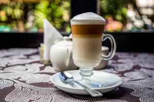 a glass of coffee on a plate with a spoon at HOTEL EL PAN NUESTRO in Tepoztlán
