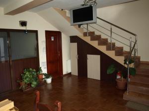 a living room with a staircase with a flat screen tv at Pensiunea Dor de munte in Arefu
