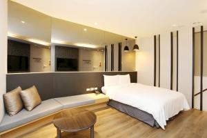 SUNLINE Motel & Resort في بايهة: غرفة نوم بسرير كبير وأريكة