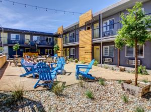 a person sitting in blue chairs in front of a building at Americana Modern Hotel in Redding