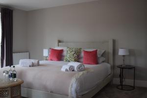 una camera da letto con un grande letto con asciugamani di The Manor House at Quorn a Loughborough