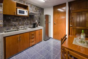 a kitchen with a sink and a refrigerator at Suite Studio Serviced Apartments in Mérida