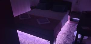 um pequeno quarto com uma cama com luz roxa em Apartmani Maras em Split