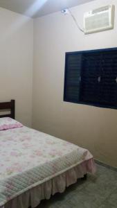 um quarto com uma cama e ar condicionado na parede em minha casa por dia em Goiânia