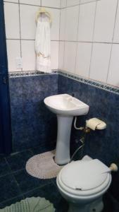 La salle de bains est pourvue de toilettes blanches et d'un lavabo. dans l'établissement minha casa por dia, à Goiânia