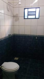 a bathroom with a toilet and a window at minha casa por dia in Goiânia