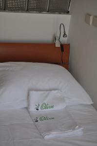 a white pillow on a bed with a lamp at Apartments Olive i Lavender in Mandre