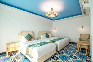 a hotel room with two beds and a chandelier at Hotel Hilal in Cyberjaya