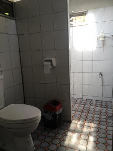 a bathroom with a toilet and a trash can at Baan Bua Guest House in Chiang Rai