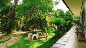 a garden with a table and chairs on the grass at Baan Bua Guest House in Chiang Rai