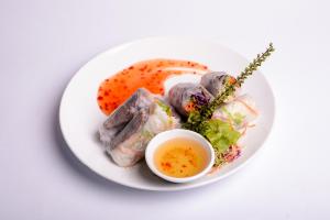 a plate of food with meat and a dipping sauce at Cat Ba Sweet Potato Homestay in Cat Ba