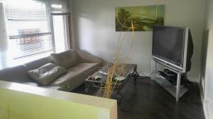 a living room with a couch and a flat screen tv at McMaster Accommodations in Hamilton