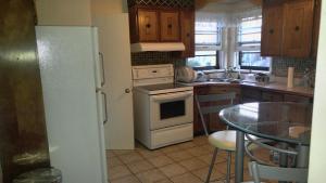 uma cozinha com um frigorífico branco e uma mesa em McMaster Accommodations em Hamilton