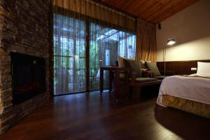 1 dormitorio con chimenea, 1 cama y 1 sofá en Grace Garden Villa en Fengshan